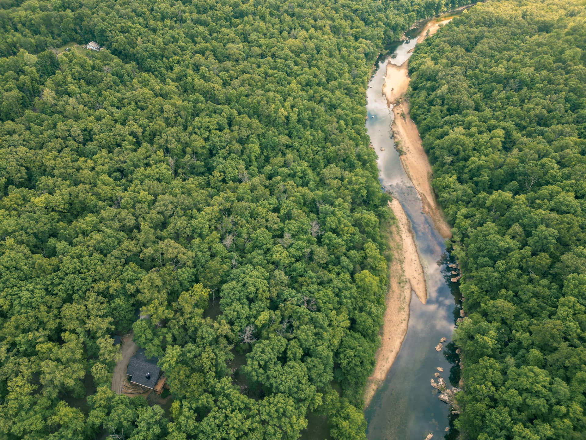 Boat cutting across an Ozark lake at golden hour